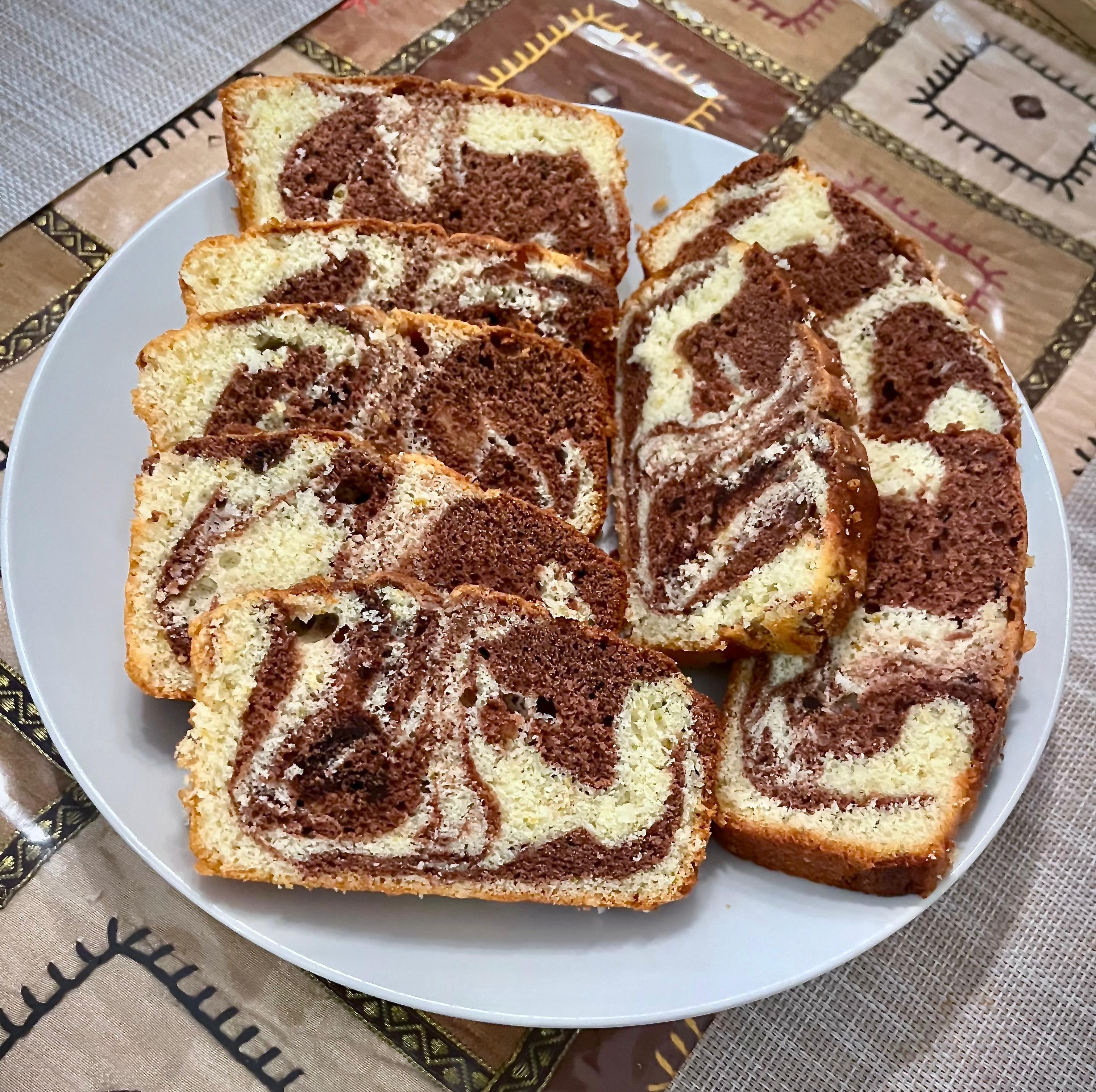 Slices of homemade marble cake with chocolate and vanilla swirls arranged on a white plate